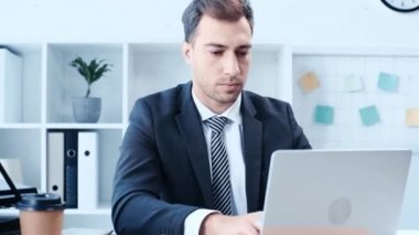 ofiste masada otururken laptop kullanarak hayal kırıklığı işadamı