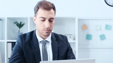 ofiste dizüstü bilgisayar kullanırken kazanan jest gösteren mutlu işadamı