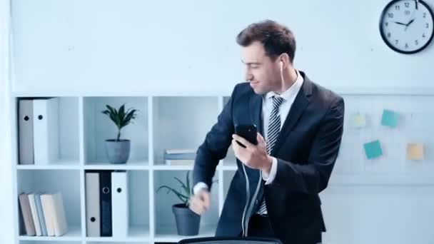 Веселый Бизнесмен Танцует Офисе Слушая Музыку Наушниками Смартфоном — стоковое видео