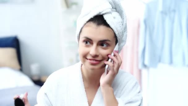 Mujer Feliz Albornoz Aplicando Polvo Facial Hablando Teléfono Inteligente — Vídeo de stock