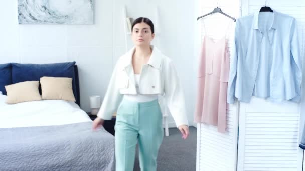 快乐的女人试图在卧室的白色和绿松石色的衣服 — 图库视频影像
