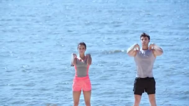 Giovane Uomo Donna Abbigliamento Sportivo Che Esercitano Insieme Sulla Spiaggia — Video Stock