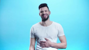 neşeli adam gesturing ve mavi gülüyor 