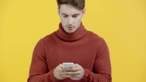 Bezorgde Man Trui Texting Smartphone Geïsoleerd Geel — Stockvideo