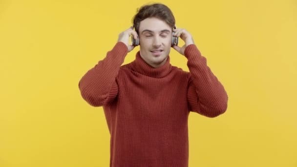 Hombre Sonriente Auriculares Apuntando Con Dedo Aislado Amarillo — Vídeos de Stock