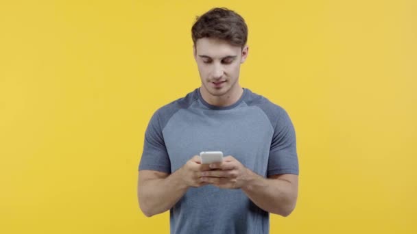 Lachende Man Texting Smartphone Geïsoleerd Geel — Stockvideo