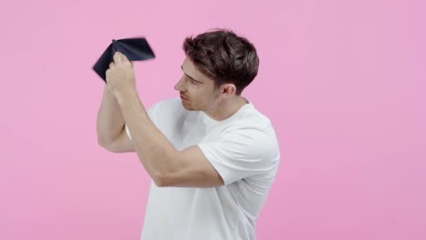 ピンクに隔離された空の財布を振る貧しい男 — ストック動画