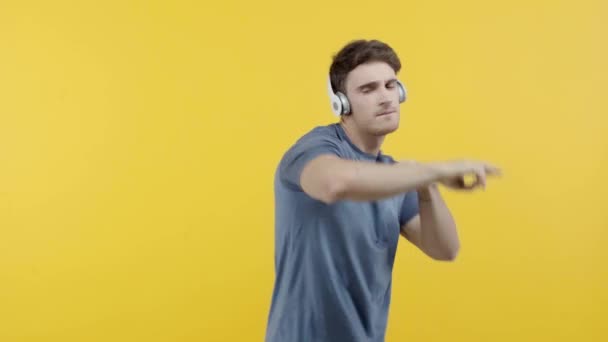 兴奋的人跳舞在耳机隔离在黄色 — 图库视频影像