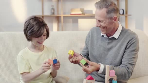 Grandfather Grandson Laughing While Putting Building Blocks Eyes — Stock Video