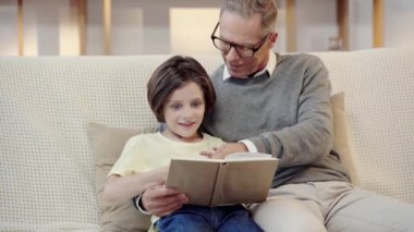 dedesi ve torunu oturma odasında birlikte kitap okuma