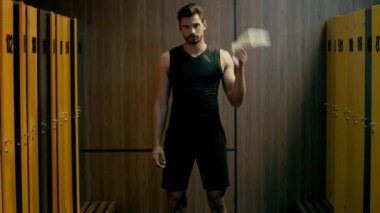 Sakallı sporcu omzuna havlu takıyor.