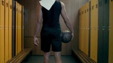 Sporcu basketbolu dolaba koyuyor. 
