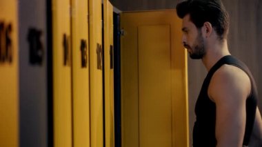 Dolapların yanında fitness takip cihazı kullanan sporcunun seçici odağı