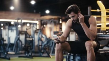 Spor salonunda müzik dinleyen mutlu bir sporcu. 