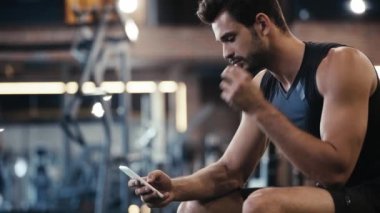 Neşeli sporcu spor salonunda müzik dinliyor. 