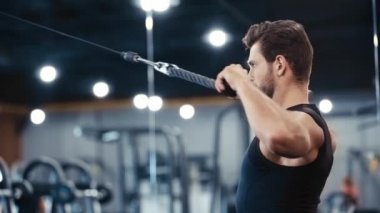 Yakışıklı sakallı sporcu spor salonunda egzersiz yapıyor. 