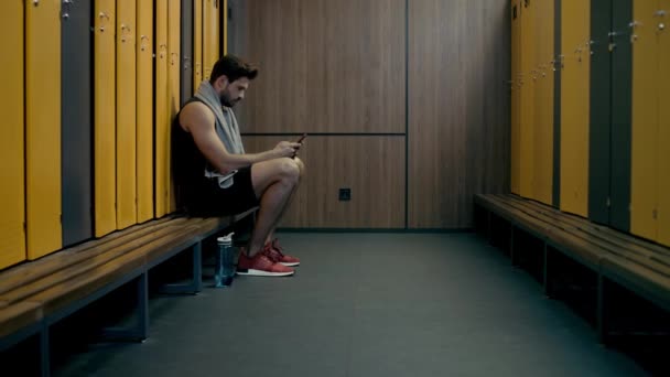 スマートフォンを持ちながらおしゃべりする幸せなスポーツマン — ストック動画