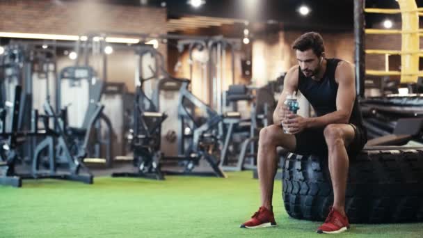 Deportista Escuchando Música Agua Potable Gimnasio — Vídeo de stock