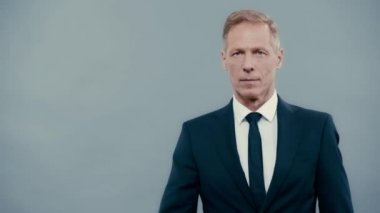 Takım elbiseli gülümseyen iş adamı başparmağını gösteriyor 