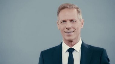 Kameraya bakarak kıyafetli gülümseyen iş adamı 