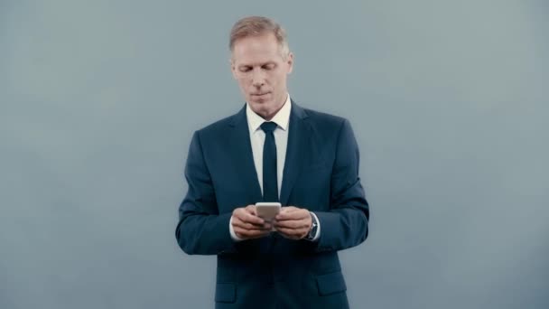 Geschäftsmann Anzug Lächelt Und Nutzt Smartphone — Stockvideo