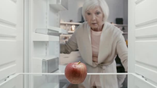 Triste Mujer Abriendo Nevera Tomando Manzana — Vídeo de stock