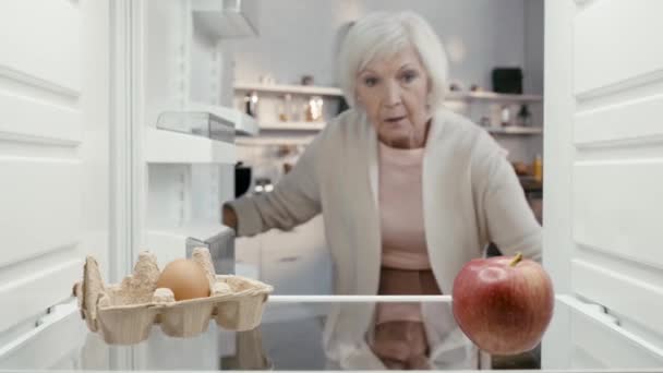 Σοκαρισμένη Γυναίκα Άνοιγμα Ψυγείο Και Λήψη Μήλου — Αρχείο Βίντεο