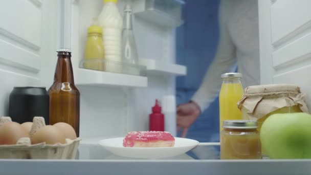 Hungriger Mann Holt Nachts Donut Aus Kühlschrank — Stockvideo