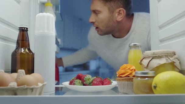 Πεινασμένος Άνθρωπος Λαμβάνοντας Φράουλα Και Δοχείο Σαντιγί Από Ψυγείο — Αρχείο Βίντεο