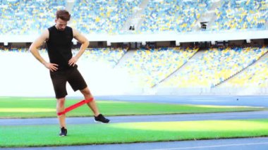 Sporcu direniş bandıyla egzersiz yapıyor.