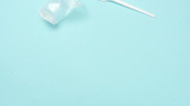 Plastik bardakların, kaşıkların ve çatalların mavi üzerindeki hareketini durdur