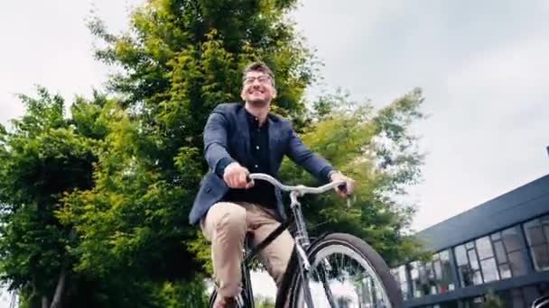 戴眼镜骑自行车的快乐男人的低视角 — 图库视频影像