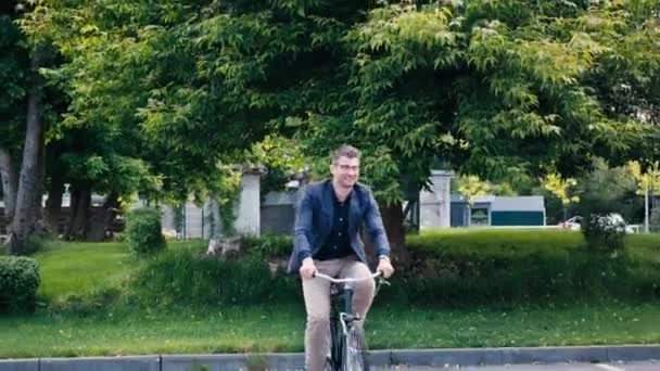 Szczęśliwy Człowiek Okularach Jazda Rowerze Asfalcie Pobliżu Zielonych Drzew — Wideo stockowe