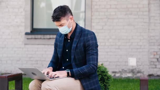 Freelancer Máscara Médica Usando Laptop Afuera — Vídeo de stock