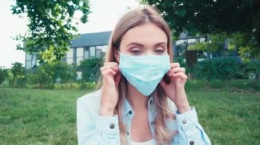 Genç öğrenci parkta maskesini çıkarıyor. 