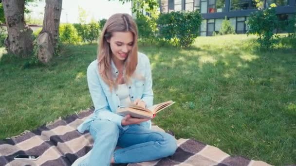 Uśmiechnięty Student Czyta Książkę Kratę Parku — Wideo stockowe