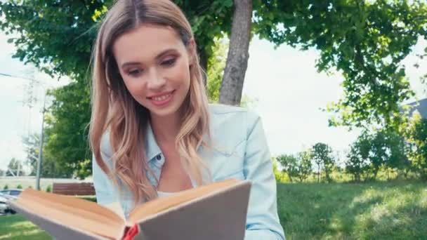 Hermosa Estudiante Sonriendo Mientras Lee Libro Parque — Vídeos de Stock