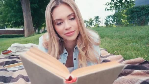 笑顔学生読書本上の再生で公園 — ストック動画