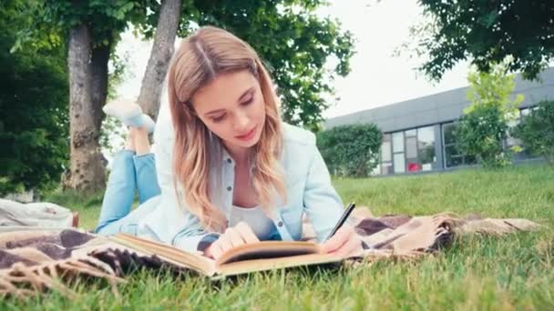 Student Czytania Książki Pisania Notebooku Kratę Parku — Wideo stockowe