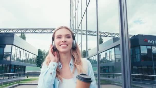 Estudiante Feliz Auriculares Sosteniendo Café Para Mientras Camina Por Calle — Vídeos de Stock