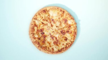 Mavi arka planda pizza yiyen adamın en iyi görüntüsü.