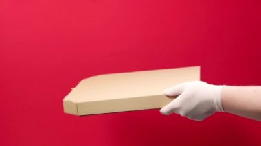 Kırmızı arka plandaki adama pizza kutusu veren kurye görüntüsü