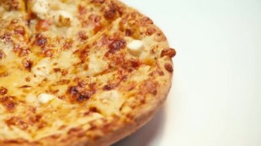 Beyaz arka planda dönen peynirli pizzanın yakın görüntüsü