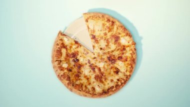 Pizzayı mavi arka plana koyan adamın üst görüntüsü