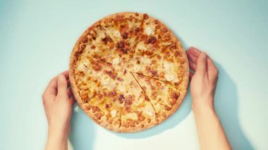Mavi arka planda peynirli pizza yiyen adamın en iyi görüntüsü.