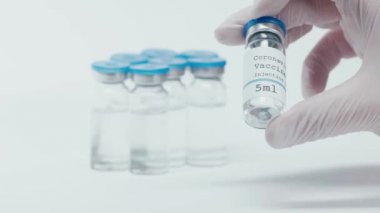Coronavirus aşısı beyaz bilim adamının elinde şişe üzerine yazılmış.