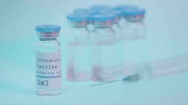 Coronavirus aşısı mavi eldivenli bilim adamının yanındaki şişede yazıyor.