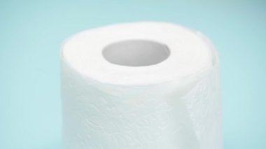 Mavi arkaplanda dönen tuvalet kağıdı görünümünü kapat