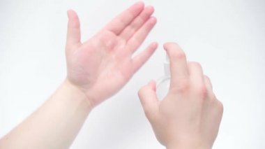 Beyaz arka plana el dezenfektanı süren bir adam görüntüsü.