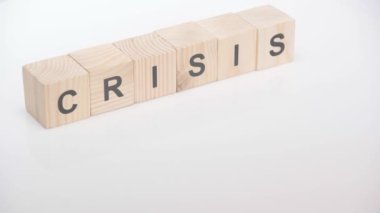 Beyaz arkaplanda kriz harfleri yazan küplerin yanına dolar atan kişi